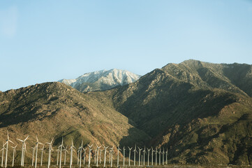 Fototapeta premium Wind turbines located by mountains in California on a sunny day