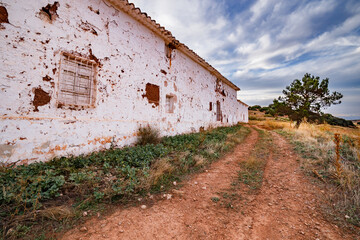 Fototapeta na wymiar Road next to an abandoned house in Carrizosa