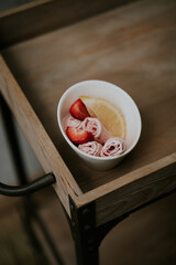 Strawberry rolled ice cream with strawberries and lemon on wood cart