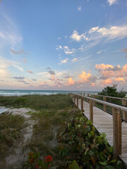 Boardwalk into Florida beach at sunset with cloudy sky © Cavan