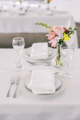 Elegant wedding table setting with pink floral accent