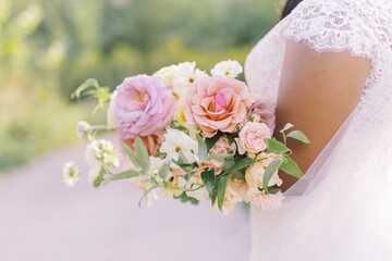Soft pink bridal bouquet held in bride's arms