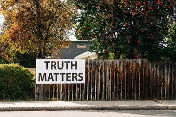 Truth Matters sign hanging on fence outside