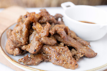 Fried pork with garlic and pepper with Thai spicy dipping sauce (Jaew sauce).