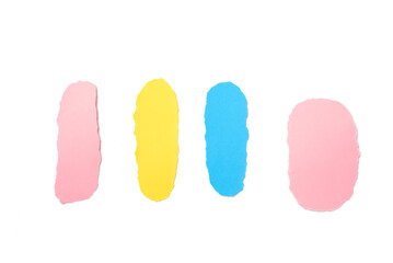 Set of torn papers of different colors on a white paper background.