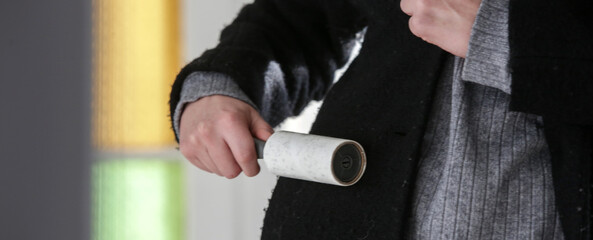 Hair remover roller. Woman using reusable clothes lint roller cleaner.	