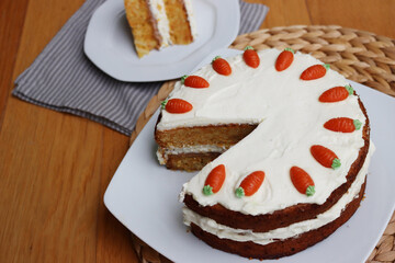 Sliced homemade carrot cake with mascarpone cream cheese icing and mini marzipan carrot decorations