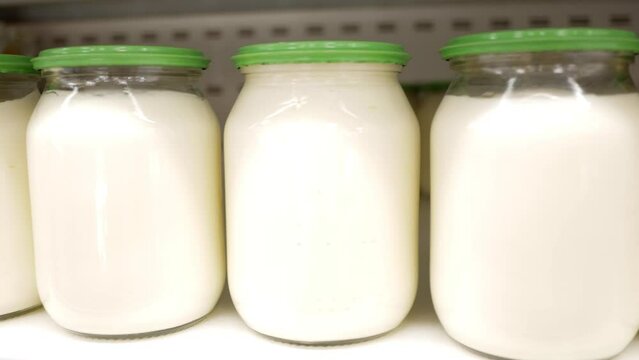 White sauce or sour cream on display on a store shelf. Mayonnaise in glass jar.