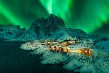 Aurora Borealis over the romantic fishing village of Hamnoy and the snow-capped Festhelltinden peak...