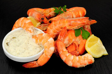 Group of freshly cooked shell on crevettes with lemon and parsley herb garnish
