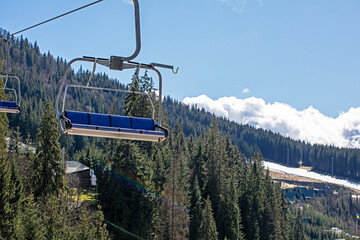empty ski lift over ancient spruce trees. Active recreation