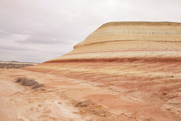 Unique geological feature known as tiger-striped mountains, showcasing layers of sedimentary rock in warm tones that resemble the stripes of a tiger