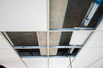 Installation au plafond de câble électrique pour alimenter des luminaires