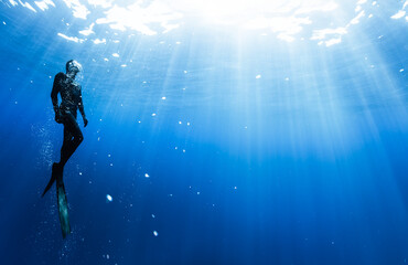 Freediver Swimming in Deep Sea With Sunrays. - 781887264