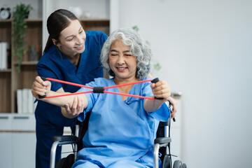 senior woman doing exercise at clinic with physiotherapist. help of a personal trainer during a...