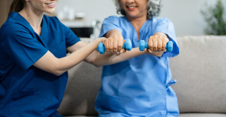 senior woman doing exercise at clinic with physiotherapist. help of a personal trainer during a rehabilitation session.