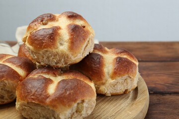 Tasty hot cross buns on wooden table, closeup