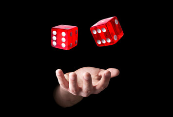 Man throwing red dice on black background, closeup