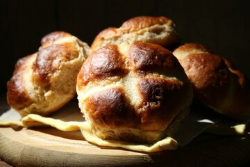 Tasty hot cross buns on table against dark background, closeup