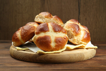 Tasty hot cross buns on wooden table, closeup