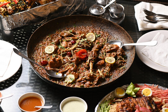 Desi chicken karahi topped with lemon slices and ginger