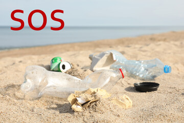 Fototapeta na wymiar Word SOS and garbage scattered on beach near sea. Recycling problem