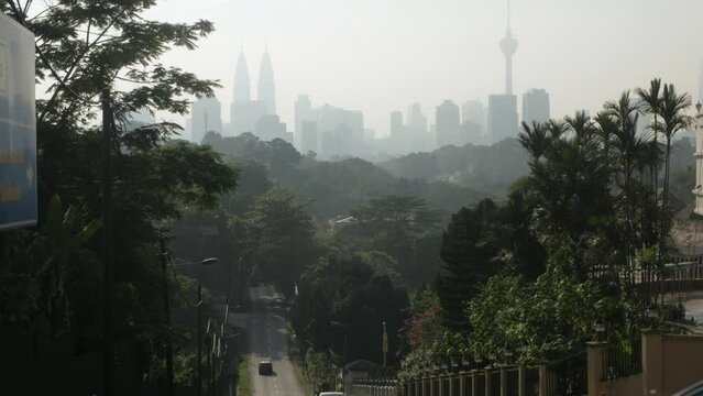 view local street leads into the downtown city center of Kuala lumpur in Malaysia with modern skyscraper building financial district and sunrise in the sky