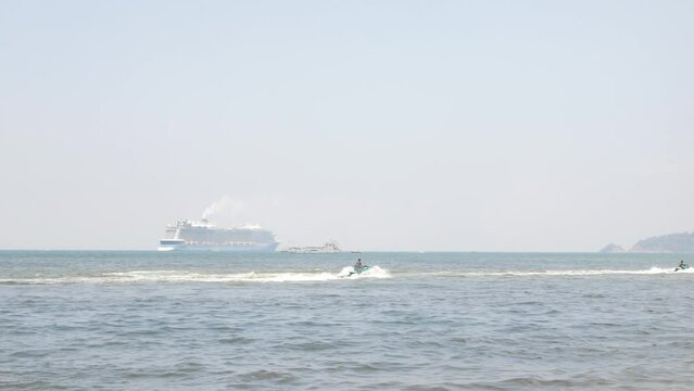 view to the ocean sea with giant cruise ship in the sea and some small ship,speedboat and jet ski water outdoor activity under sumer holiday sunny sunshine sky