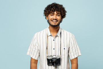 Traveler smiling fun Indian man he wear white casual clothes looking camera isolated on plain blue...