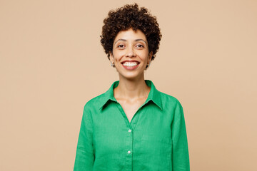Young satisfied smiling happy cheerful woman of African American ethnicity she wear green shirt casual clothes looking camera isolated on plain pastel light beige background studio. Lifestyle concept.
