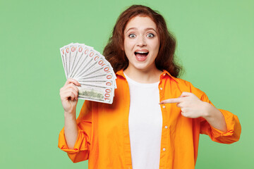 Young shocked ginger woman she wear orange shirt white t-shirt casual clothes hold in hand point...