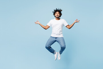 Full body young happy Indian man wear white t-shirt casual clothes jump high hold spreading hands...
