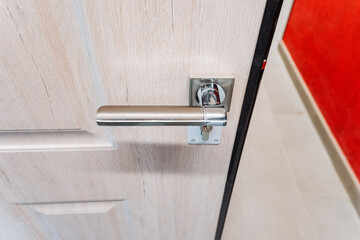 Silver handle of the front door to the house, top view of the handle of the holder, door to the...