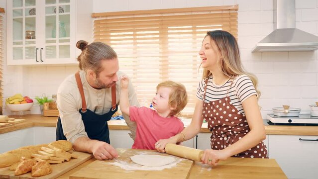 Caucasian attractive couple baking bakery with son in kitchen at home. 