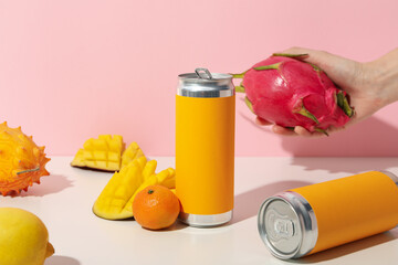 Tropical fruit, tin cans and hand on light pink background