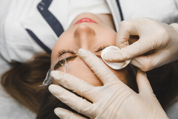 A cosmetologist applies permanent makeup to the eyebrows - eyebrow tattoo. eyebrow perm - obrazy, fototapety, plakaty