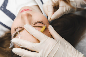 A cosmetologist applies permanent makeup to the eyebrows - eyebrow tattoo. eyebrow perm