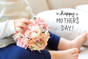 Mother's Day message with toddler boy with flowers on a couch - 781922231
