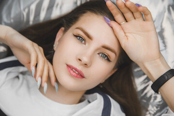 Fototapeta premium Beautiful model with full lips and permanent eyebrows. Facial skin care of a beautiful woman. cosmetology of permanent makeup. Portrait of a woman with permanent eyebrows and manicure