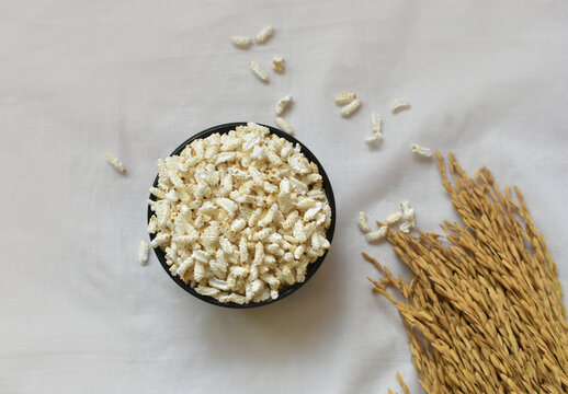 Popped Rice or Nel Pori also known as Puffed Lahi or Karthigai Pori in a wooden bowl on a white background. Low-calorie diet food concept. Selective focus on bowl and food.