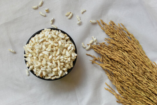Popped Rice or Nel Pori also known as Puffed Lahi or Karthigai Pori in a wooden bowl on a white background. Low-calorie diet food concept. Selective focus on paddy.