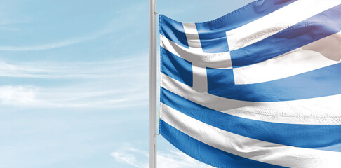 Greece national flag with mast at light blue sky. - obrazy, fototapety, plakaty