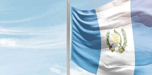 Guatemala national flag with mast at light blue sky.