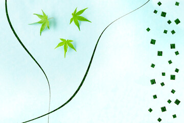 カエデの若葉と和紙の切り絵風デザイン（水色の背景）