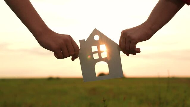 hands holding paper house, window sunset ray, happy family mortgage build new house, home buying guide, housing market trends, mortgage rates today, moving house checklist, new construction homes