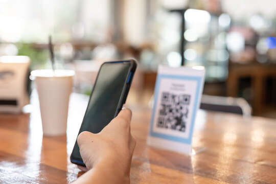 man use smartphone to scan QR code to pay in cafe restaurant with a digital payment without cash. Choose menu and order accumulate discount. E wallet, technology, pay online, credit card, bank app.