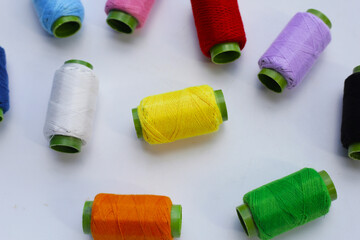 Colourful thread spools on white background