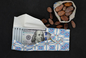 United States Dollars or American Dollars as the chocolate bar. Cocoa bean. Black background. The...