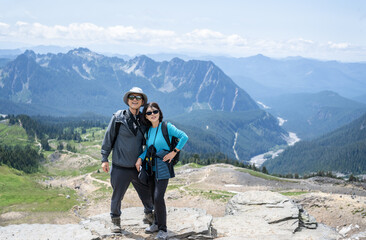 Couple posing for photos at Skyline Trail. Mt Rainier National Park. Washington State.