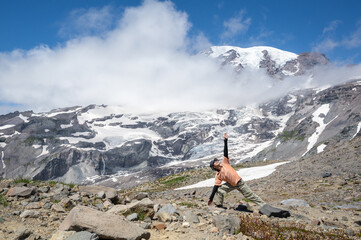 Man doing yoga poses with Mt Rainier in the background. Skyline Trail. Mount Rainier National Park. Washington State.